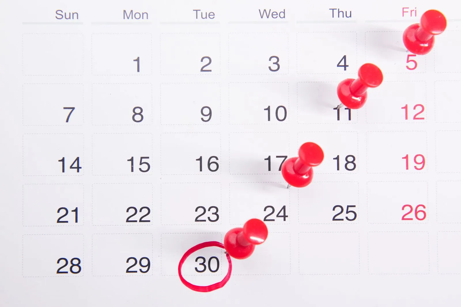 Kalender med røde knappenåle, der markerer vigtige datoer